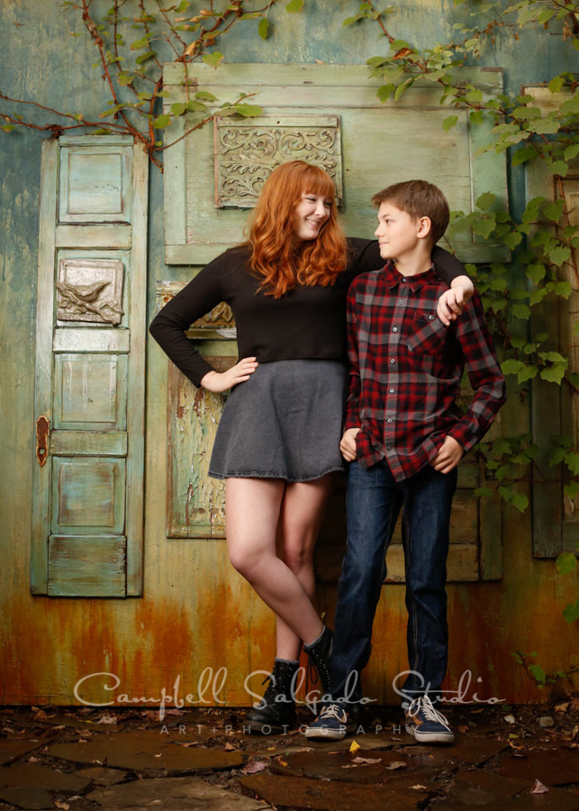  Portrait of siblings on vintage green doors background by teen photographers at Campbell Salgado Studio in Portland, Oregon. 