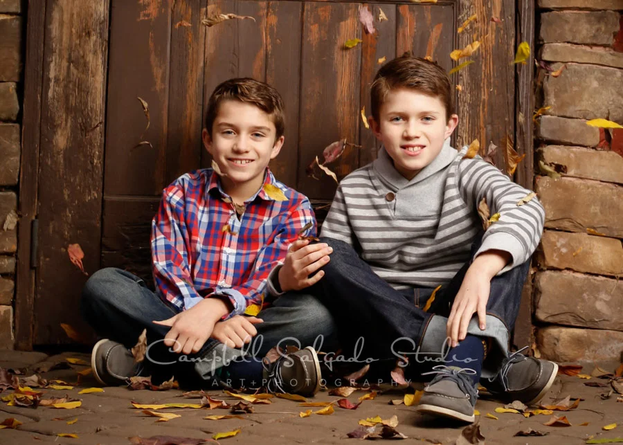 Portrait of boys on rustic door background by child photographers at Campbell Salgado Studio in Portland, Oregon.