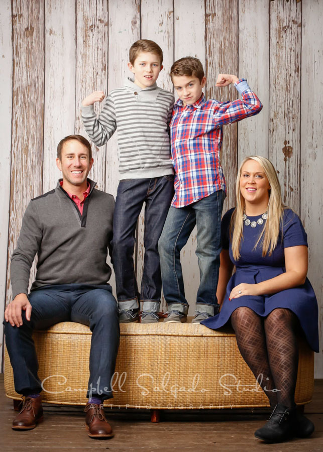  Portrait of family on white fence boards background by family photographers at Campbell Salgado Studio in Portland, Oregon. 