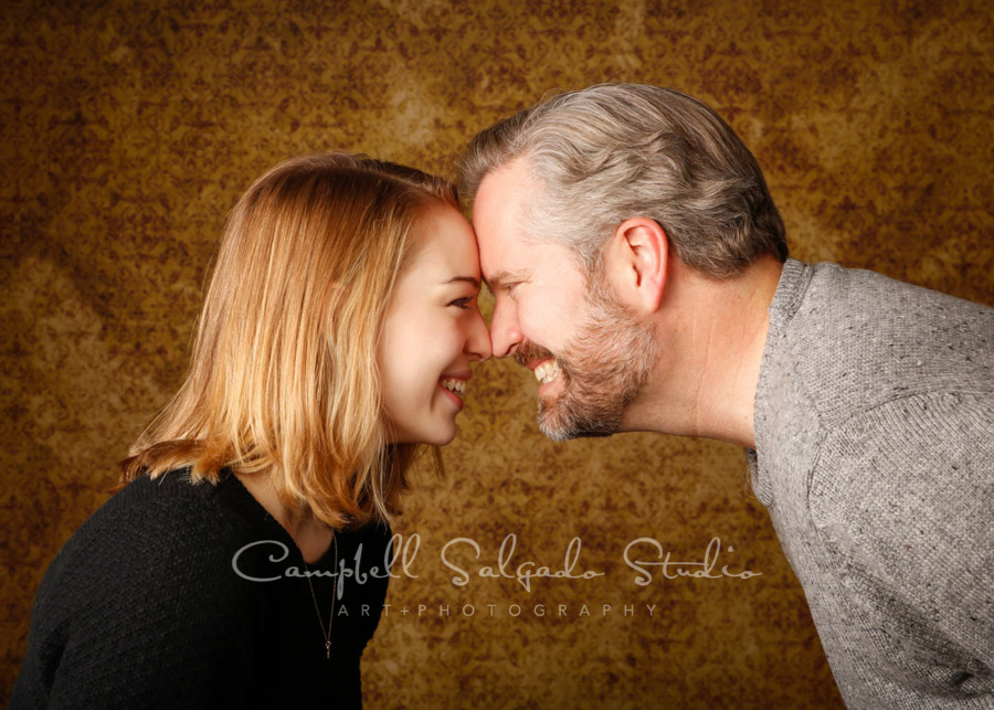  Portrait of father and daughter on amber light background by family portrait photographers at Campbell Salgado Studio in Portland, Oregon. 