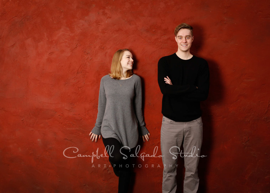  Portrait of siblings on red stucco background by family portrait photographers at Campbell Salgado Studio in Portland, Oregon. 