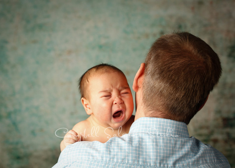  Portrait of father and son on weathered green background by family photographers at Campbell Salgado Studio in Portland, Oregon. 