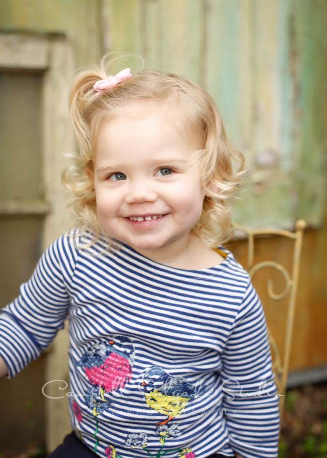  Portrait of toddler on vintage green doors background by child photographers at Campbell Salgado Studio in Portland, Oregon. 