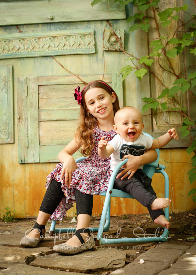  Portrait of siblings on vintage green doors background by children's photographers at Campbell Salgado Studio. 