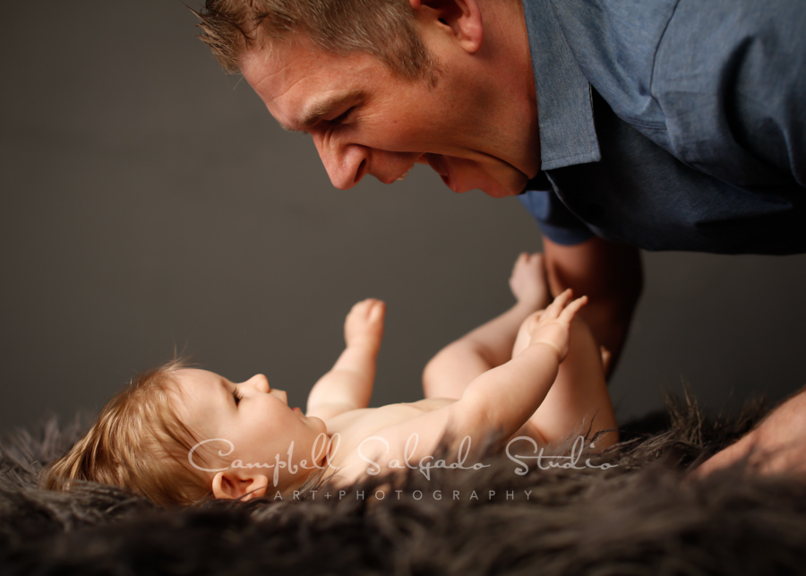  Portrait of dad and baby on grey background by family photographers at Campbell Salgado Studio in Portland, Oregon. 