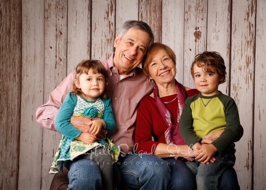 Portrait of multi-generational family on white fenceboards background by family photographers at Campbell Salgado Studio. 