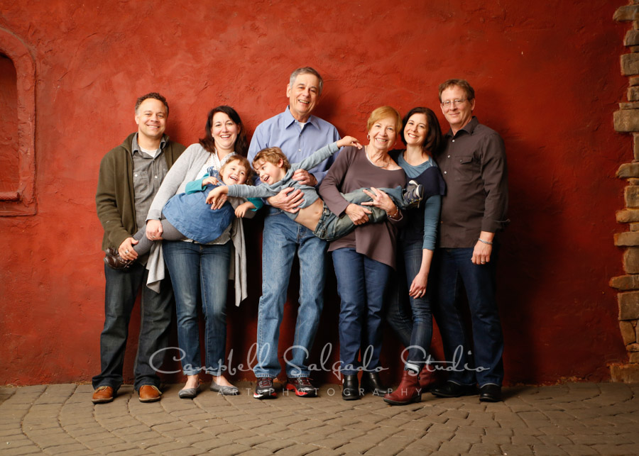  Portrait of multi-generational family on red stucco background by family photographers at Campbell Salgado Studio. 