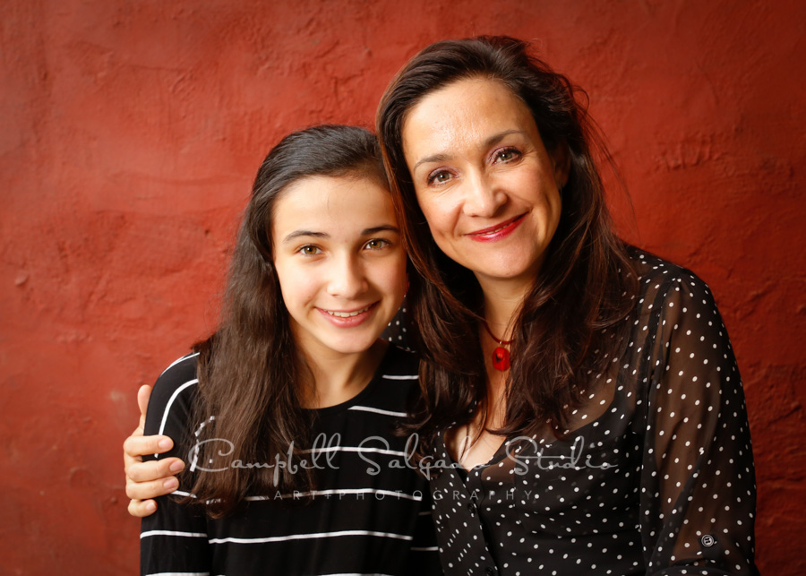  Portrait of mother and daughter on red stucco background by family photographers at Campbell Salgado Studio in Portland, Oregon. 