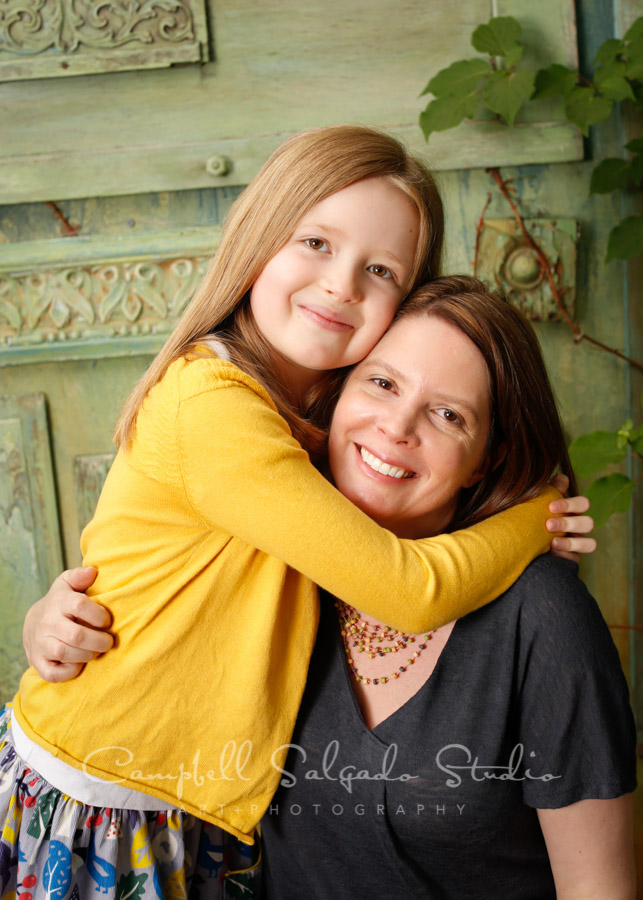  Portrait of mother and daughter on vintage green doors background by family photographers at Campbell Salgado Studio in Portland, Oregon. 