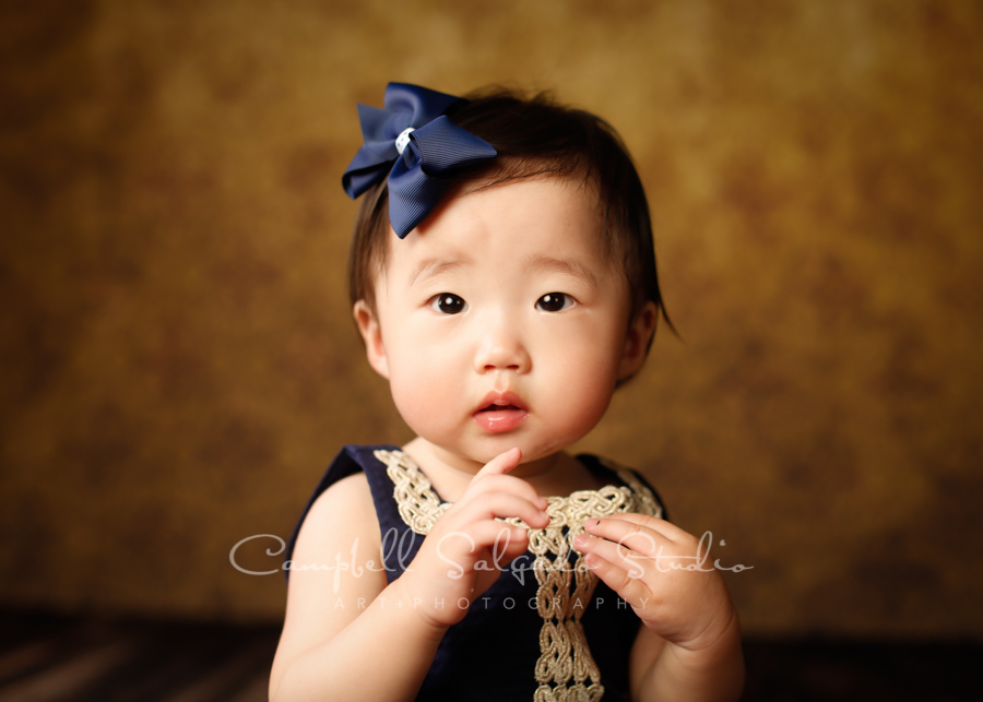  Portrait of baby girl on amber light background by child photographers at Campbell Salgado Studio in Portland, Oregon. 