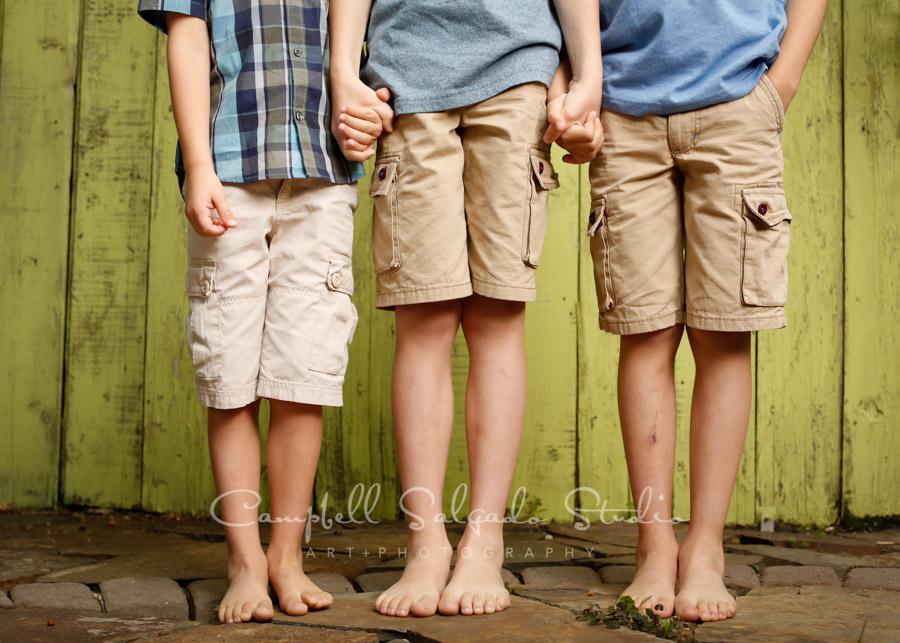  Portrait of brothers on lime fenceboards background by family photographers at Campbell Salgado Studio in Portland, Oregon. 