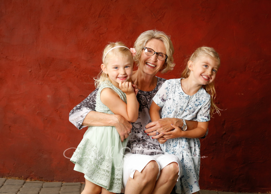  Portrait of multi-generational family on red stucco background by family photographers at Campbell Salgado Studio in Portland, Oregon. 