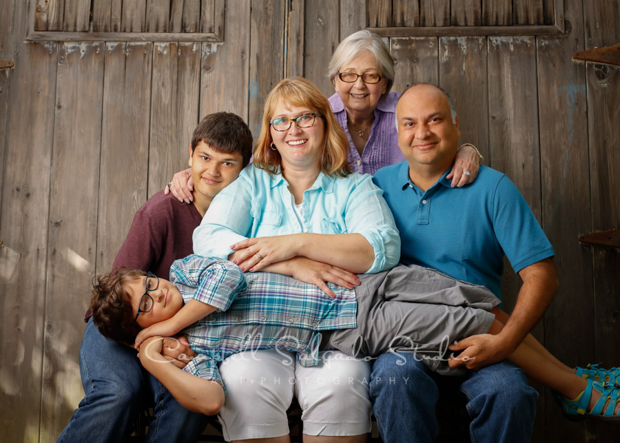  Portrait of multi-generational family on barn doors background by family photographers at Campbell Salgado Studio in Portland, Oregon. 