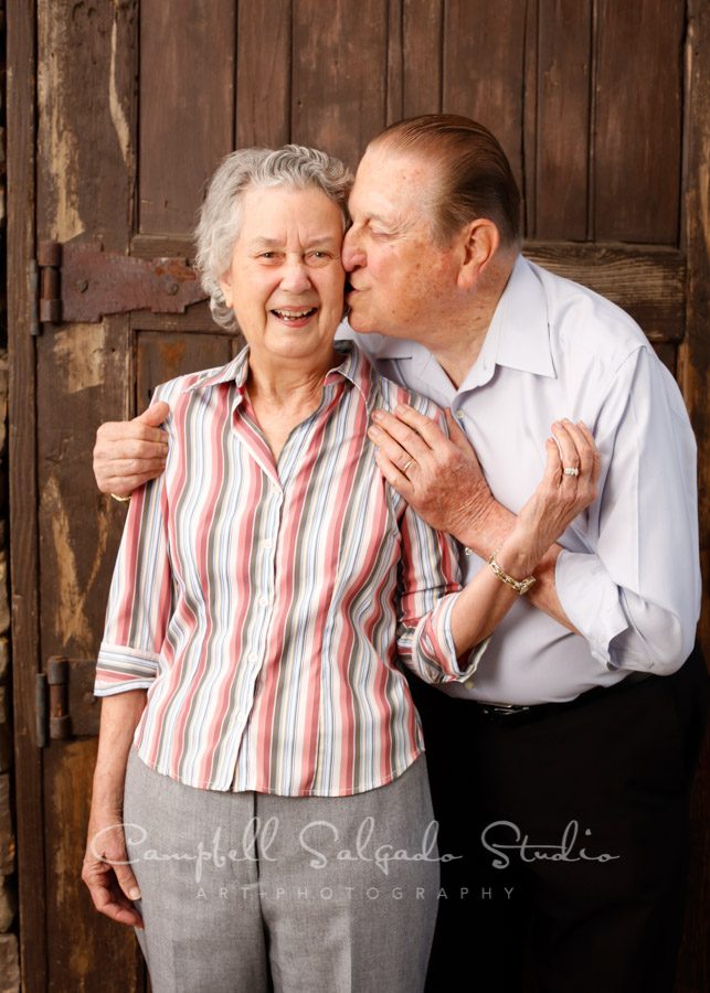  Portrait of couple on rustic door background by couples photographers at Campbell Salgado Studio in Portland, Oregon. 