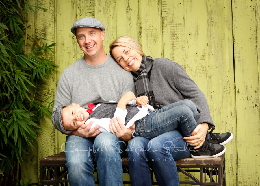  Portrait of family on lime fenceboards background by family photographers at Campbell Salgado Studio in Portland, Oregon. 