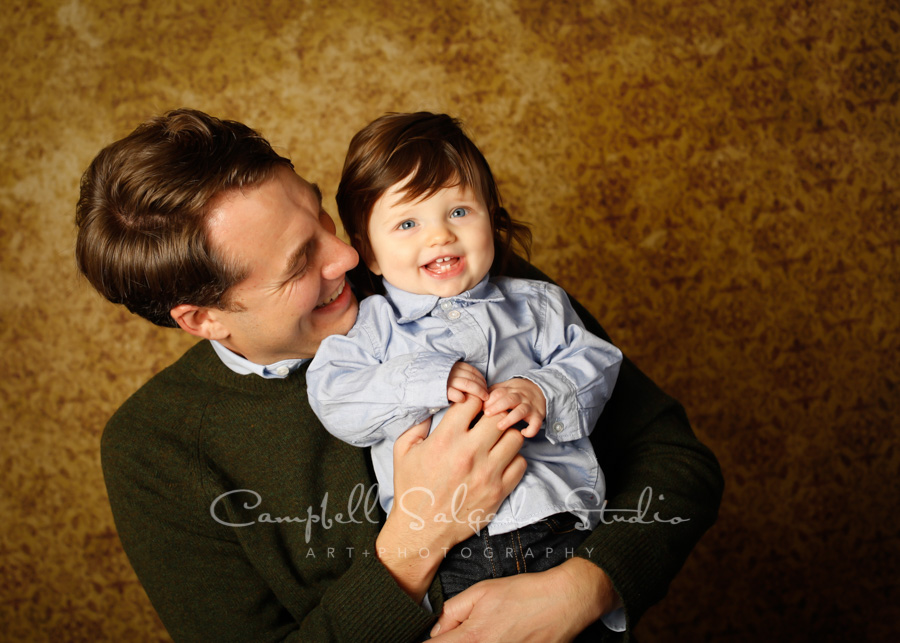  Portrait of father and child on amber light background by family photographers at Campbell Salgado Studio in Portland, Oregon. 