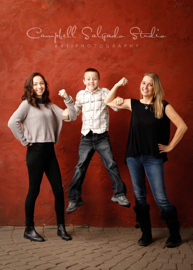  Portrait of family on red stucco background by family photographers at Campbell Salgado Studio in Portland, Oregon. 