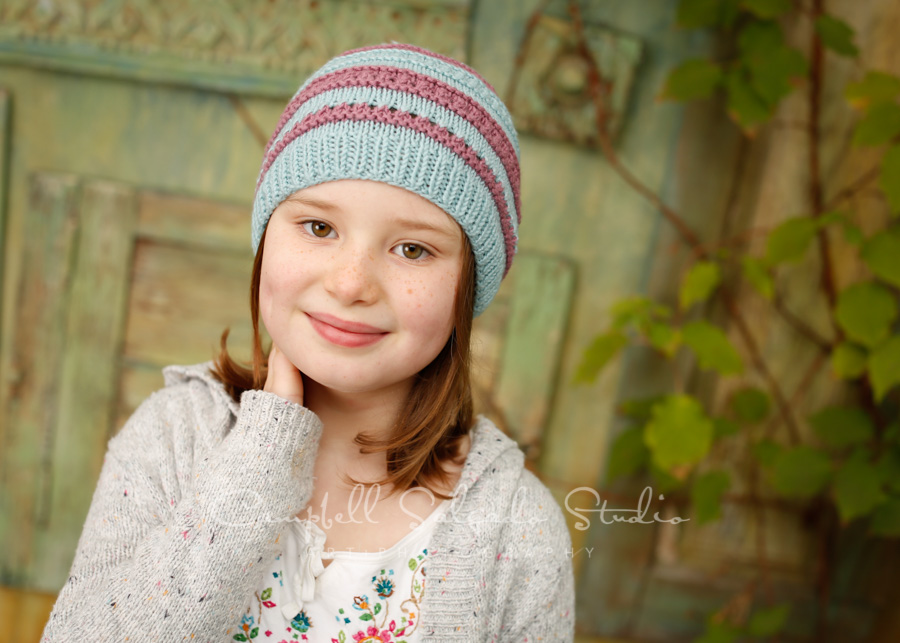  Portrait of girl on vintage green doors background by child photographers at Campbell Salgado Studio in Portland, Oregon. 