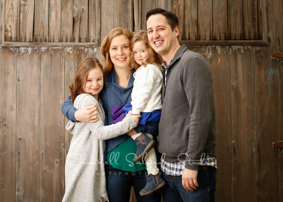  Portrait of family on barn doors background by family photographers at Campbell Salgado Studio in Portland, Oregon. 