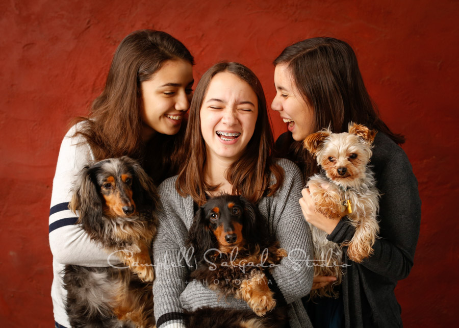  Portrait of girls on red stucco background by teen photographers at Campbell Salgado Studio in Portland, Oregon. 
