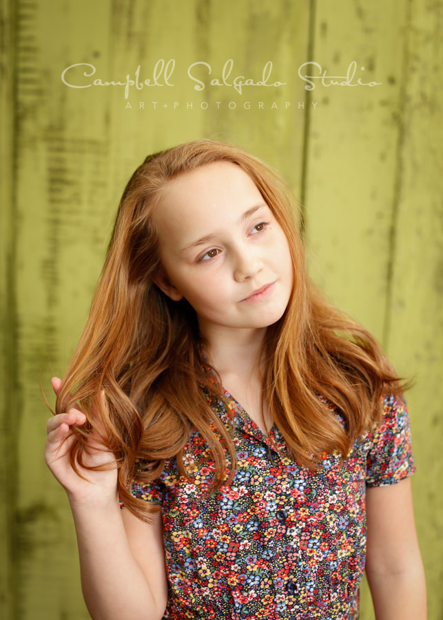  Portrait of girl on lime fenceboards background by child photographers at Campbell Salgado Studio in Portland, Oregon. 