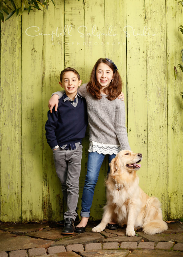  Portrait of kids on lime fence boards background by family photographers at Campbell Salgado Studio in Portland, Oregon. 