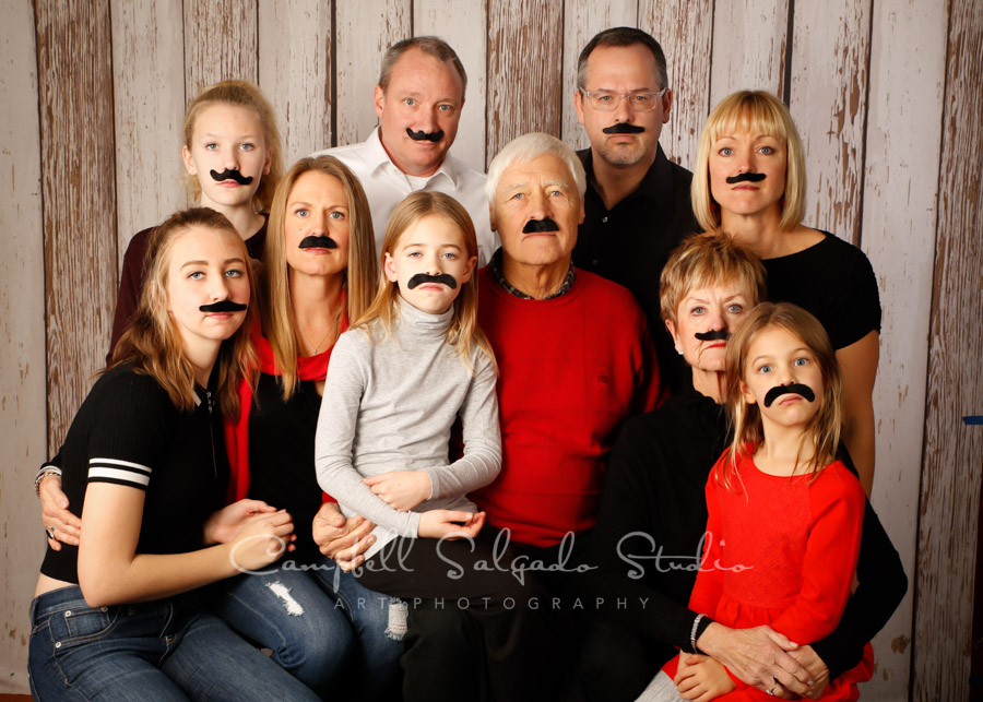  Portrait of multi-generational family on white fenceboards background by family photographers at Campbell Salgado Studio in Portland, Oregon. 