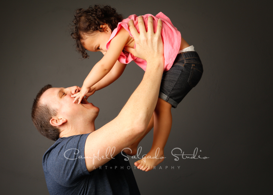  Portrait of father and daughter on gray background by family photographers at Campbell Salgado Studio in Portland, Oregon. 