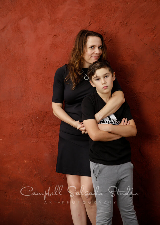  Portrait of family on red stucco background by family photographers at Campbell Salgado Studio in Portland, Oregon. 