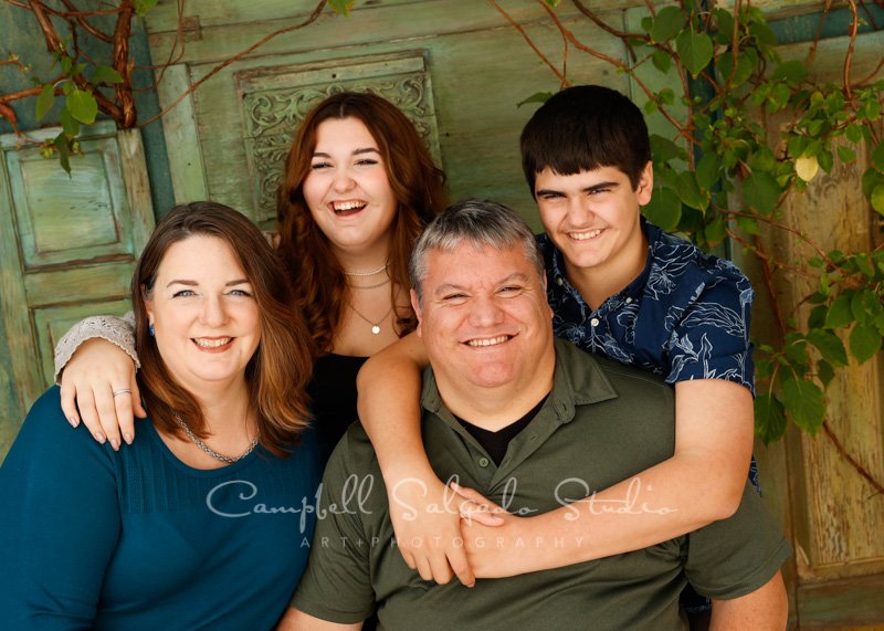  Portrait of family on vintage green doors background by family photographers at Campbell Salgado Studio in Portland, Oregon. 