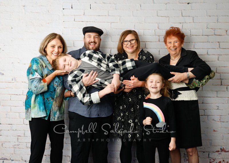  Portrait of multi-generational family on ivory brick background by family photographers at Campbell Salgado Studio in Portland, Oregon. 