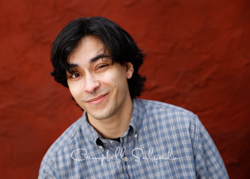  Portrait of young adult on a red stucco background by individual photographers at Campbell Salgado Studio in Portland, Oregon. 