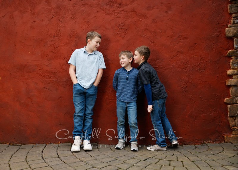 Portrait of boys on red stucco background by children’s photographers at Campbell Salgado Studio in Portland, Oregon. 