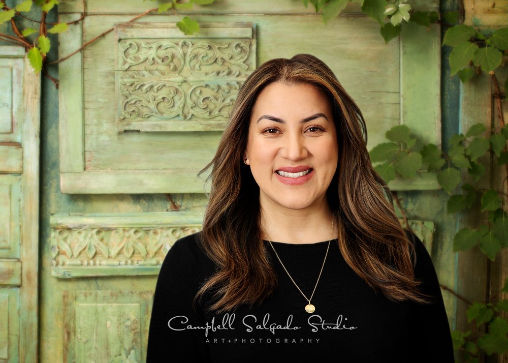  Commercial portrait of woman on vintage green doors background by commercial photographers at Campbell Salgado Studio in Portland, Oregon. 