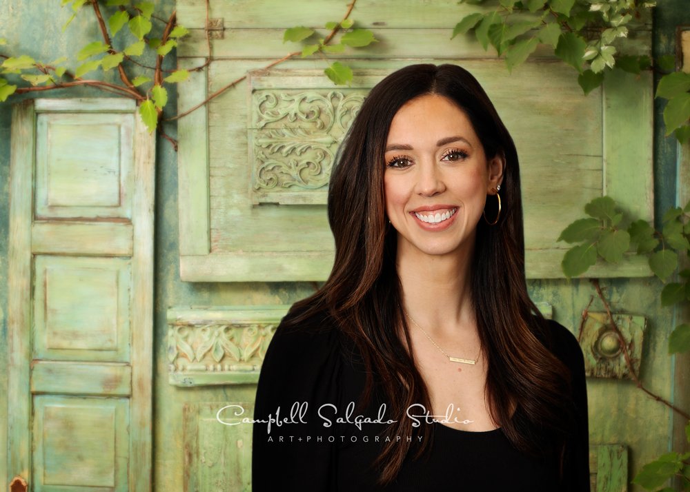  Commercial portrait of woman on vintage green doors background by commercial photographers at Campbell Salgado Studio in Portland, Oregon. 