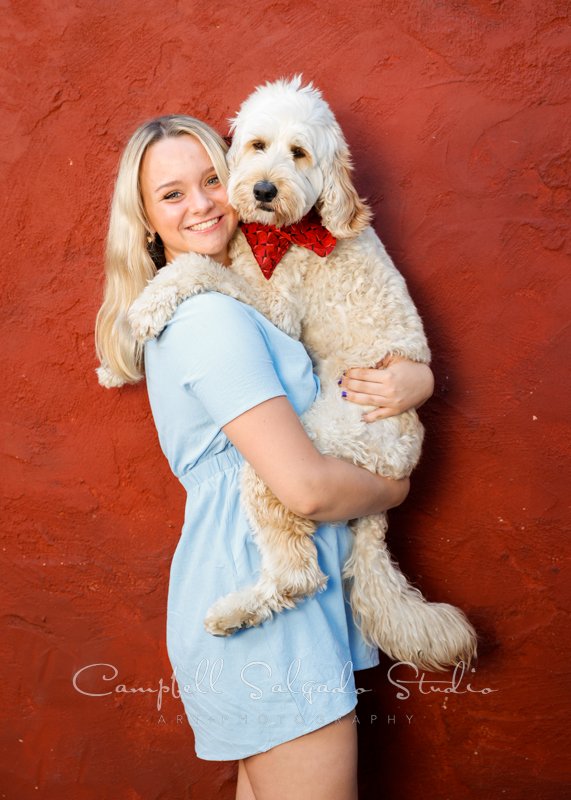  Portrait of teen and dog on red stucco background at Campbell Salgado Studio in Portland, Oregon. 