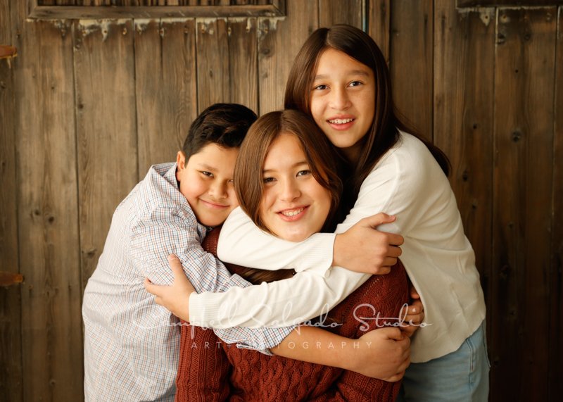  Portrait of siblings on barn doors background by family photographers at Campbell Salgado Studio in Portland, Oregon. 