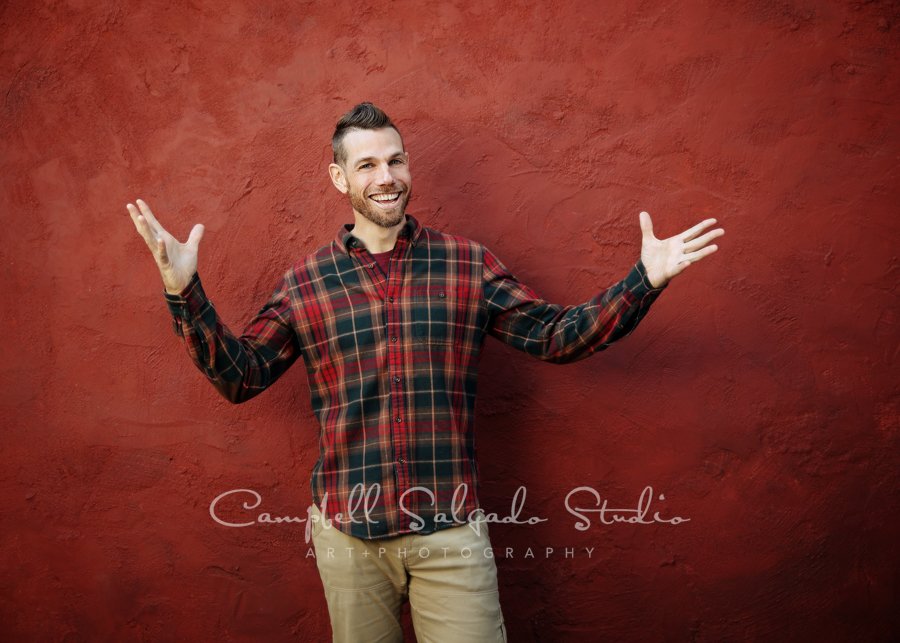  Portrait of individual on red stucco background by commercial photographers at Campbell Salgado Studio in Portland, Oregon. 