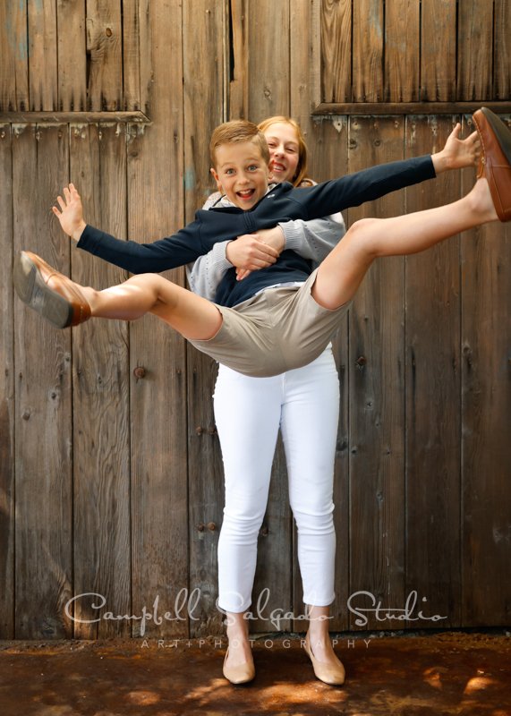  Portrait of siblings on barn doors background by child photographers at Campbell Salgado Studio in Portland, Oregon. 