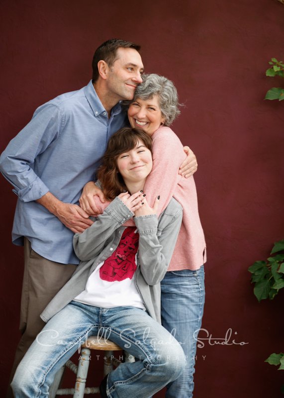  Portrait of family on plum stucco background by family photographers at Campbell Salgado Studio in Portland, Oregon. 