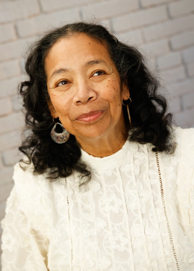  Portrait of woman on ivory brick background by individual photographers at Campbell Salgado Studio in Portland, Oregon. 