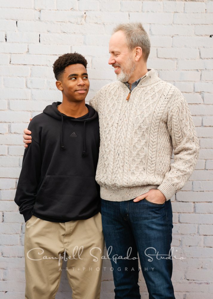  Portrait of father and son on ivory brick background by family photographers at Campbell Salgado Studio in Portland, Oregon. 