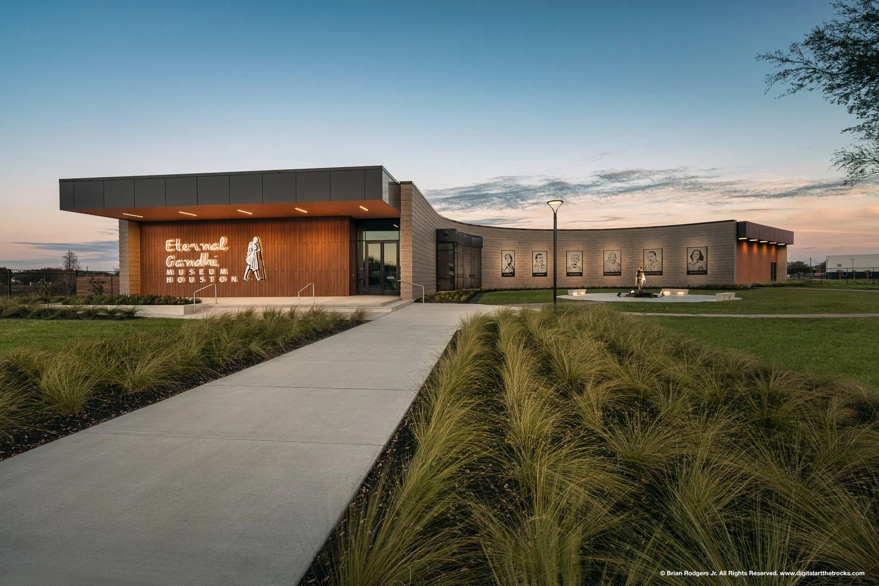 Twilight exterior architectural photography of the Eternal Gandhi Museum in Houston, Texas, featuring curved masonry walls and institutional lighting design for museum architects, cultural exhibition planners and design-build companies.