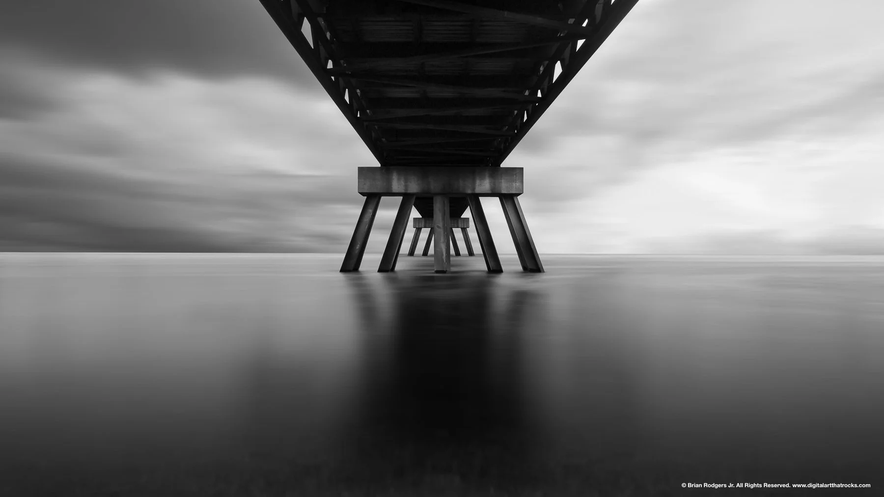 Fine art black and white long exposure photography of a bridge structure over water, licensable for display as large scale wall murals, framed gallery prints or digital crisp displays in hotel lobbies, halls or kiosks.