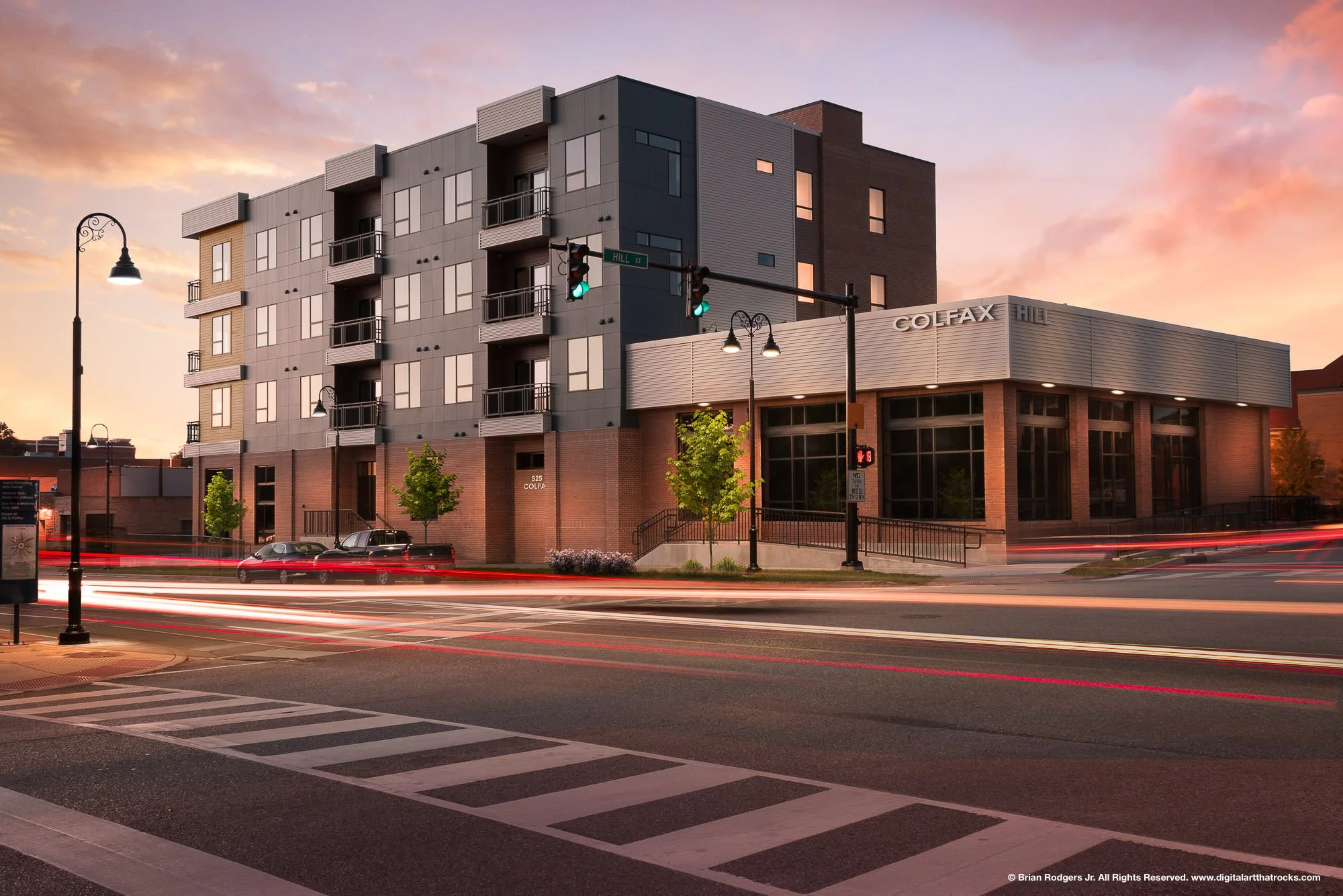 Twilight architectural photography of the Colfax Hill mixed-use development in South Bend, Indiana, featuring motion blur light trails and urban design for commercial construction firms and multi-family developers.