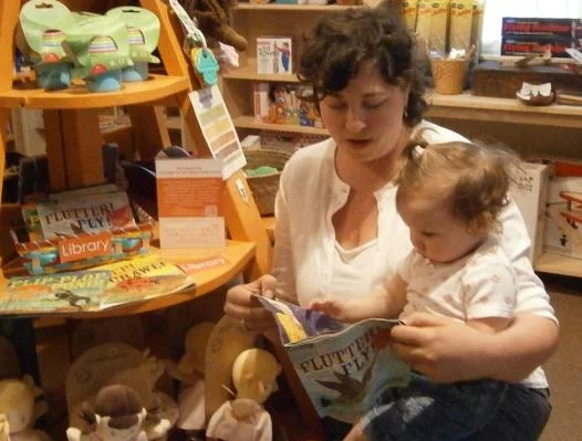 PHOTO CAPTION: Amanda Hummel, owner of The Bee’s Knees, and daughter Inez Solomon, are both fans of the INDESTRUCTIBLES, a series of non-toxic, chew-proof, rip-proof, 100% washable books for babies. Proceeds from the sale of these books over the course of the Summer will be donated to the Campaign for the Hudson Area Library. The promotion, including bright orange signs and handouts for customers, is an effort to spread the word about the Hudson Area Library’s fundraising campaign. Three other retailers are also part of this promotion – Olde Hudson, TK Home & Garden and Verdigris Tea & Chocolate Bar.