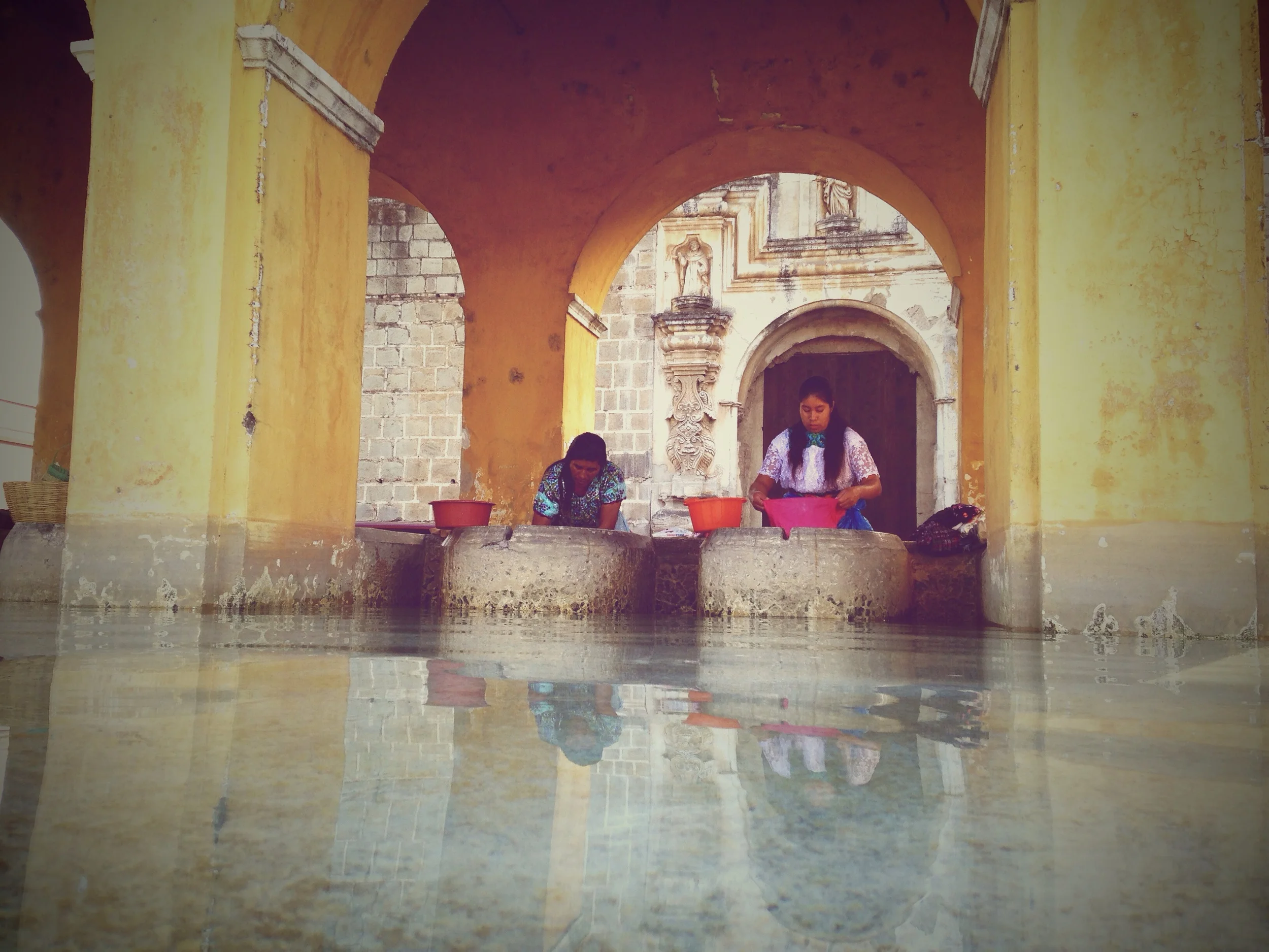 Women washing their clothes at the fountain. 