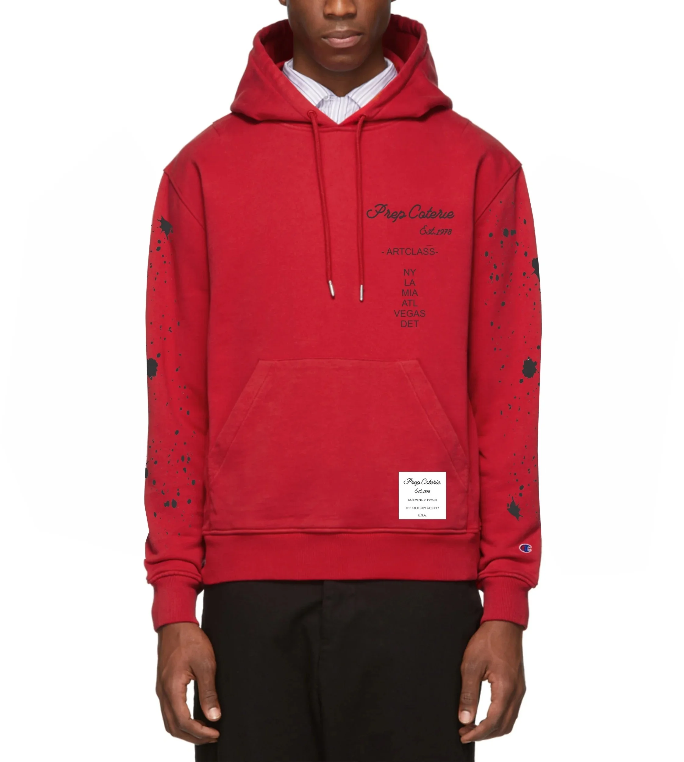 Close-up of a young man wearing a red hooded sweatshirt with black splatter paint design and text, paired with black pants, standing against a plain background.