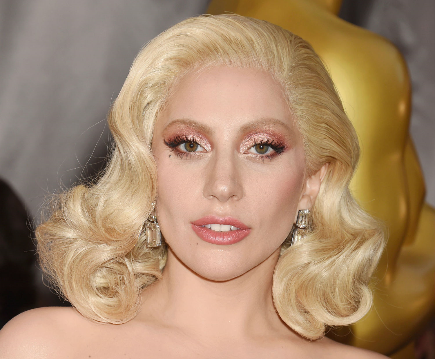Lady Gaga wears rose gold on her lips and lids at the 2016 Academy Awards. (Getty Images)