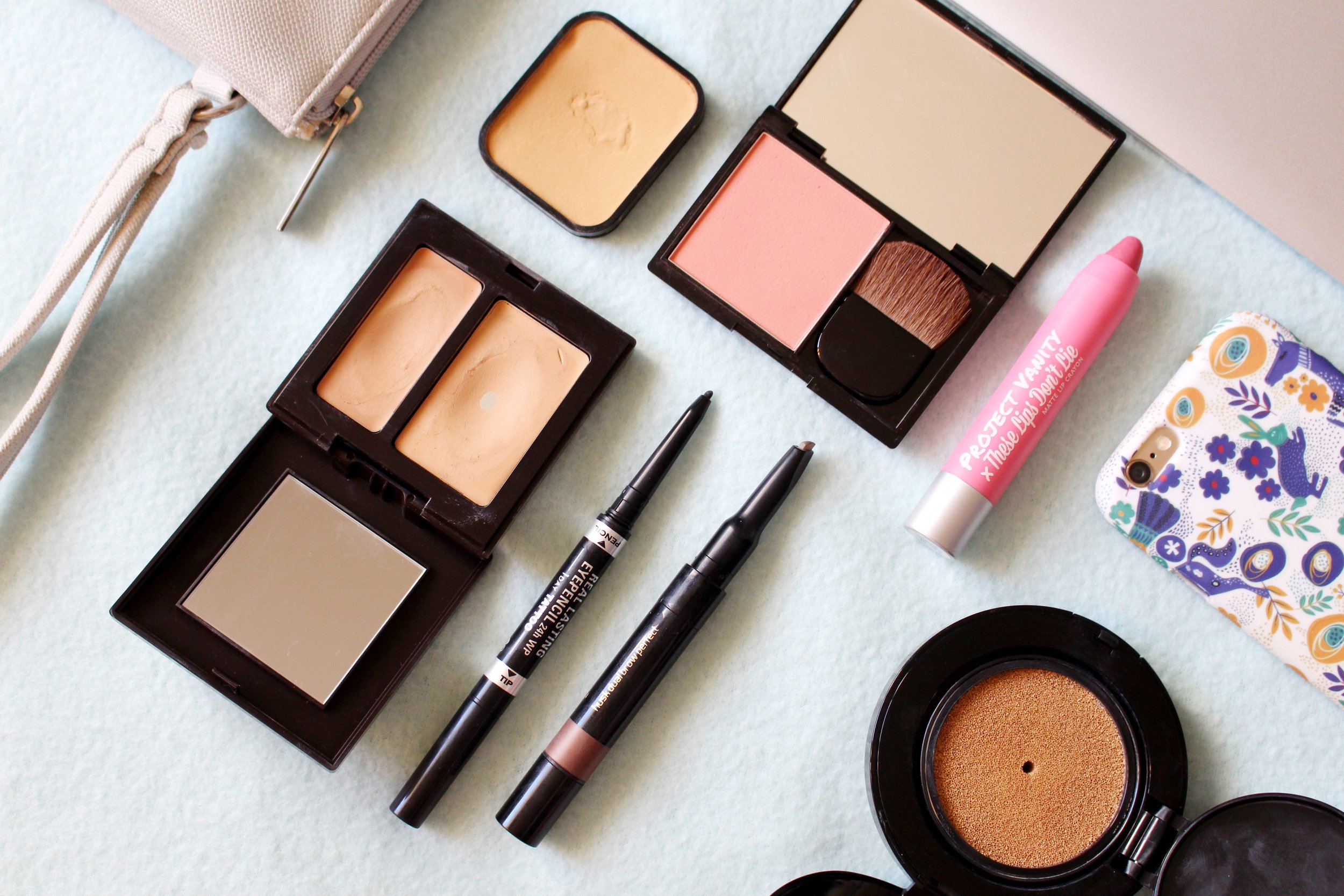 My seven-product, five-minute face: Bobbi Brown Cushion Foundation, Laura Mercier Secret Camouflage Concealer, Shiseido Sheer Mattifying Foundation, Eye of Horus Dual Brow Perfect, Pink Sugar Miss Independent Blush, and the Pink Sugar x Project Vanity Lip Crayon in Ready In Five